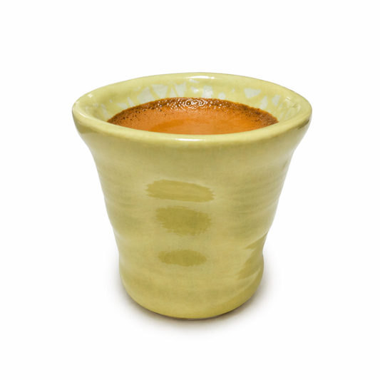 Yellow ceramic cup with a yellow interior on a white background