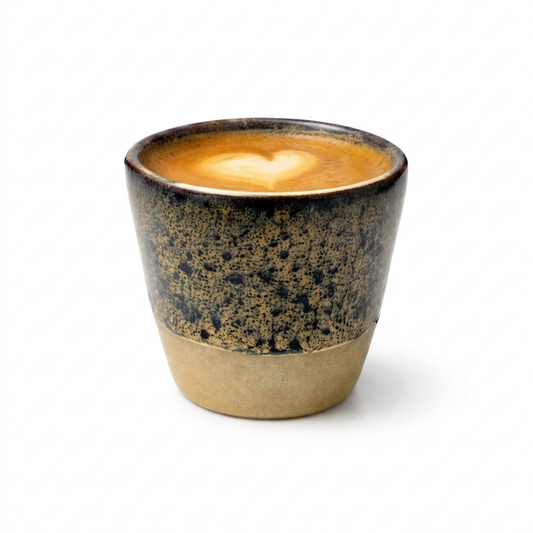 Ceramic cup with a heart-shaped foam design on a white background