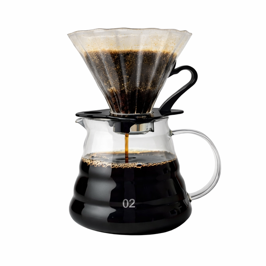 Coffee brewing device with glass carafe and paper filter on a white background