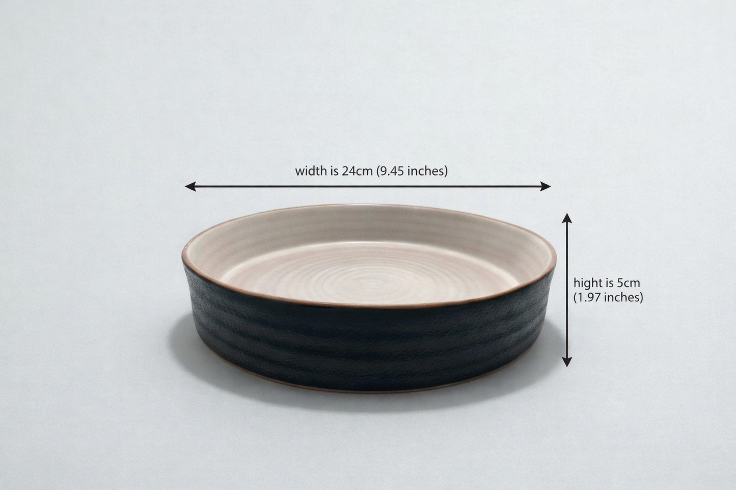 Black ceramic bowl with measurements on a light gray background