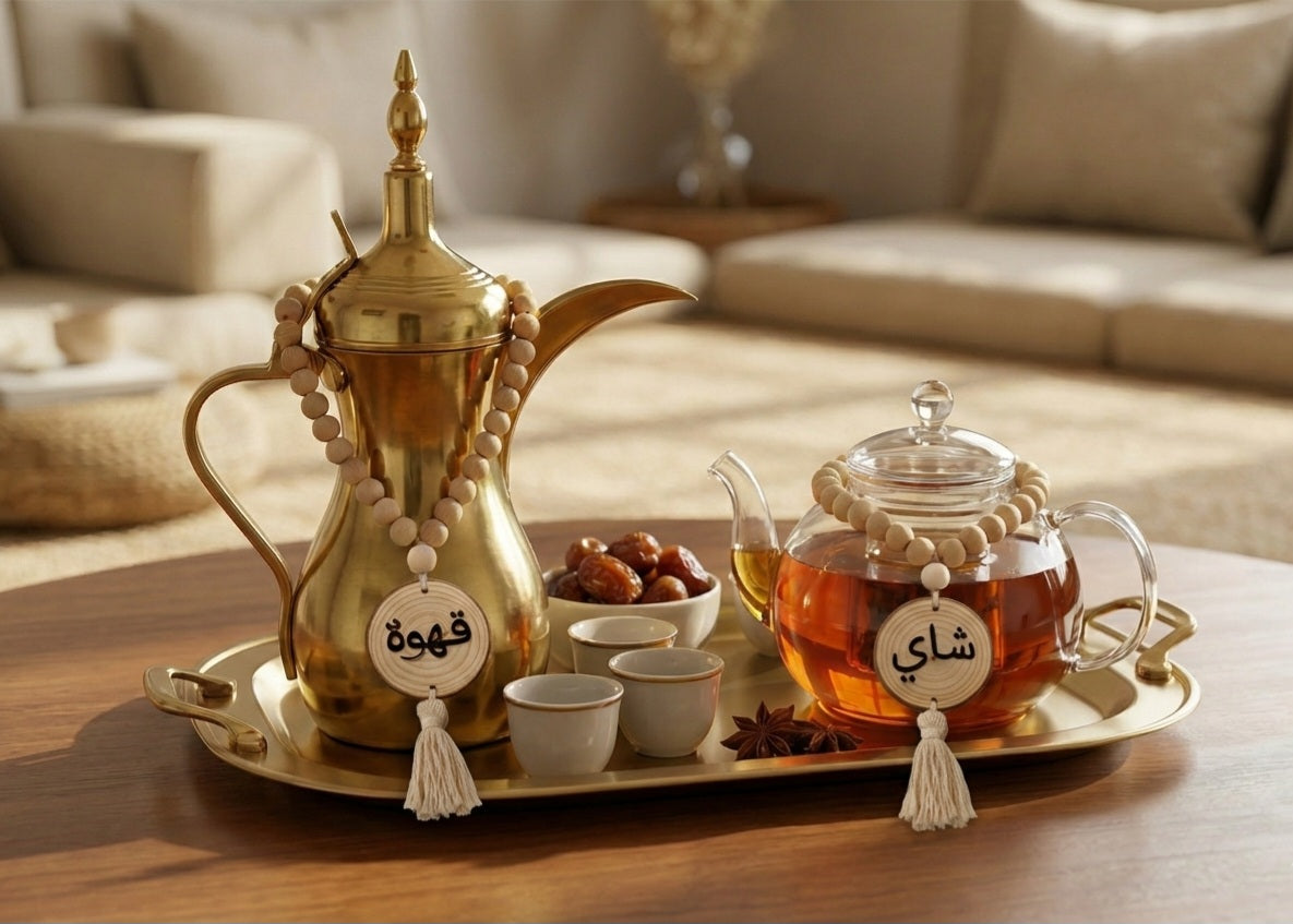 Tea set with gold teapot and glass teapot on a tray in a cozy living room.