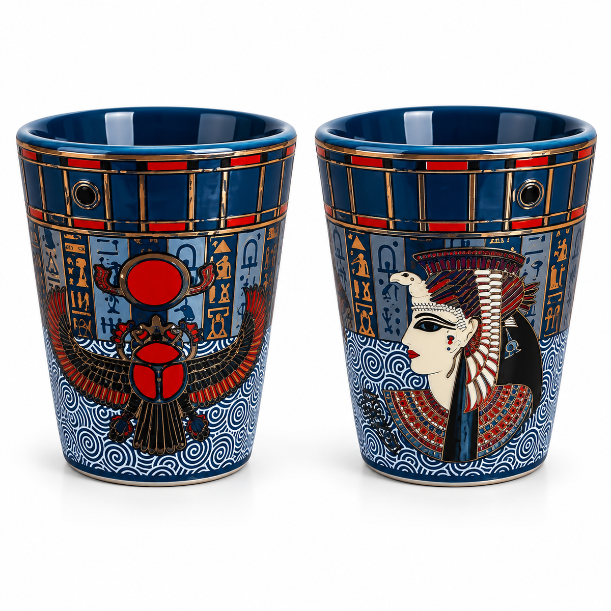 Two blue ceramic cups with Egyptian-themed designs, featuring hieroglyphs, a scarab beetle, and a profile of an Egyptian queen, shown on a white background.