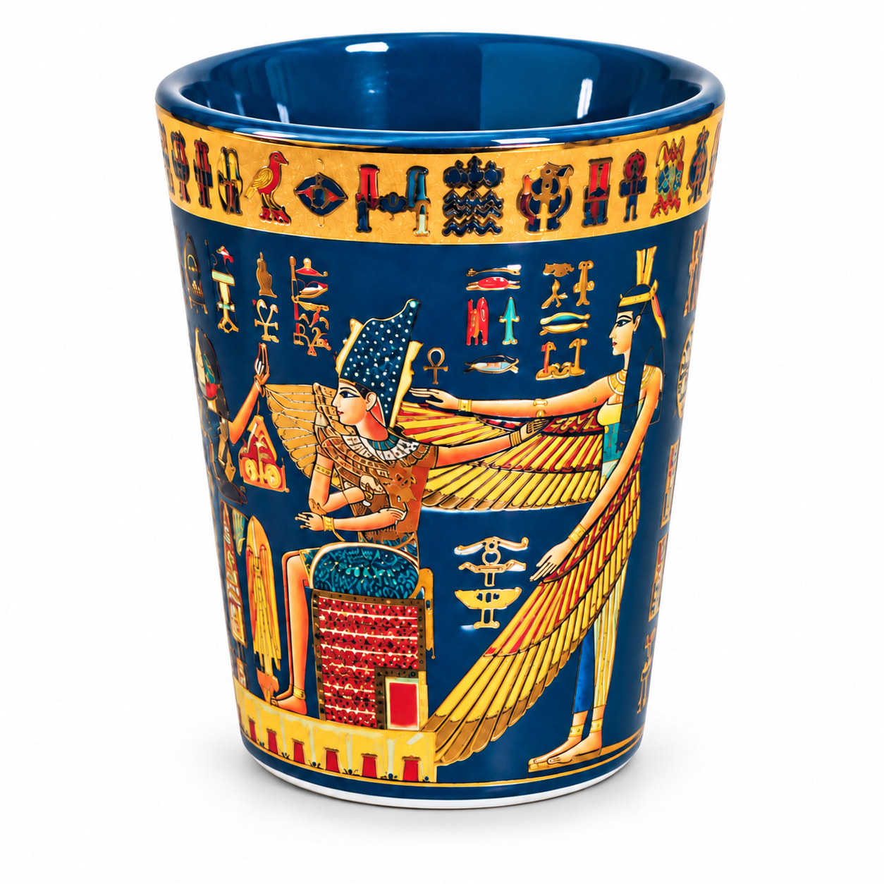 A ceramic cup featuring an Egyptian design with a deep blue background, gold hieroglyphic borders, and illustrations of gods and figures in gold, red, and white.