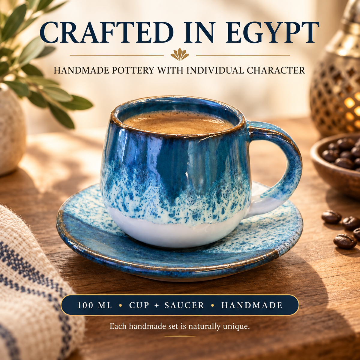 A handmade ceramic coffee cup and saucer set in a warm, rustic setting. The cup is glazed in shades of blue with a white speckled base and a rustic brown rim, filled with coffee.