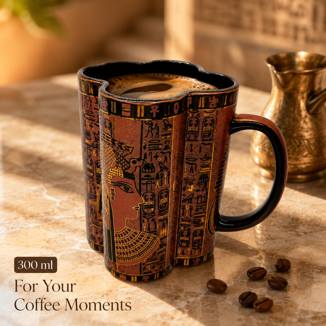 A 300 ml ceramic coffee mug with an ancient Egyptian design, featuring a pharaoh's profile and hieroglyphs in gold and black on a terracotta brown background. The mug is filled with coffee and sits on a marble table next to coffee beans, with a brass pitcher in the background.