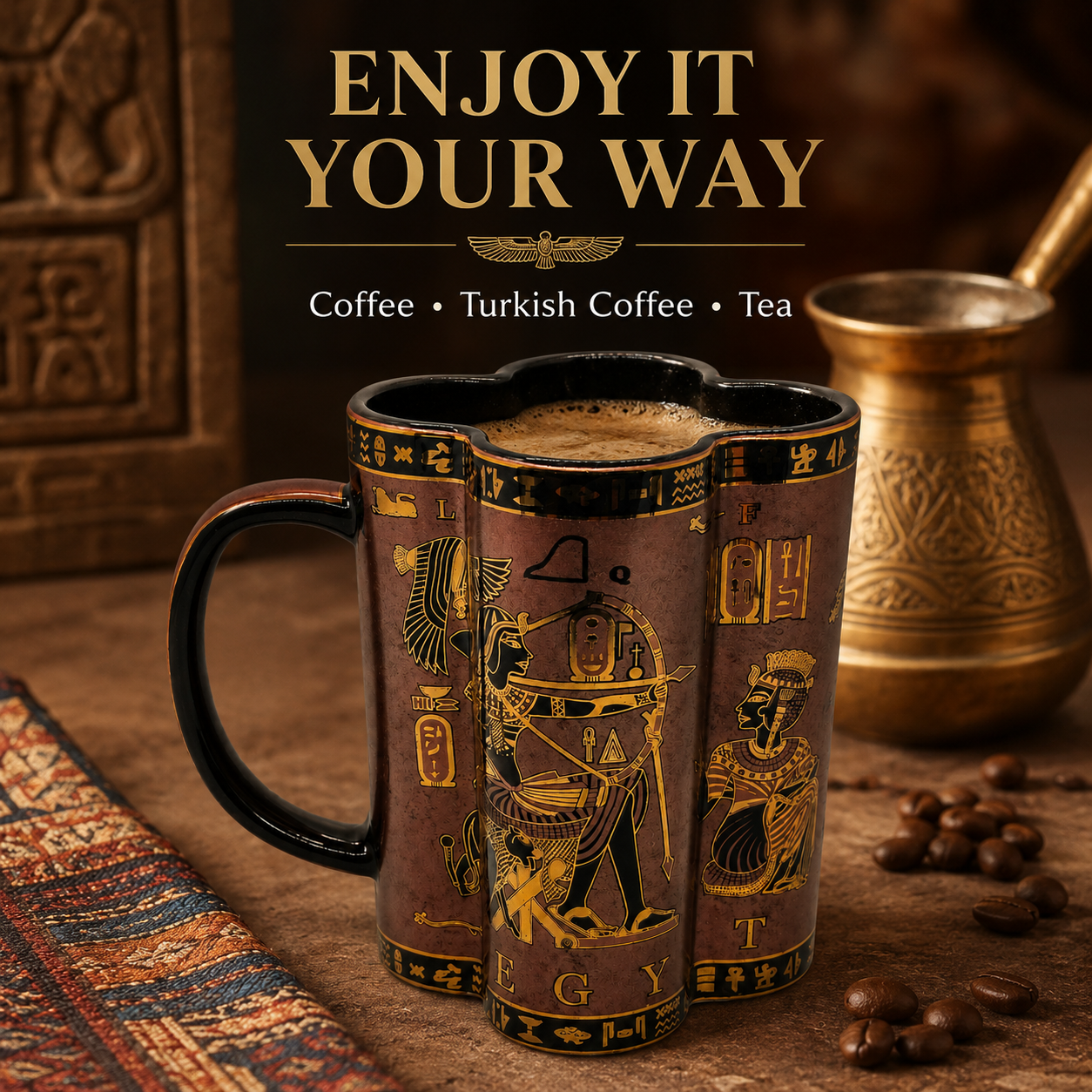 A decorative ceramic mug with an Egyptian-inspired design, featuring hieroglyphic symbols and figures in gold on a dark brown background. The mug is filled with coffee and is set on a wooden surface with coffee beans, a traditional brass Turkish coffee pot, and a patterned rug.