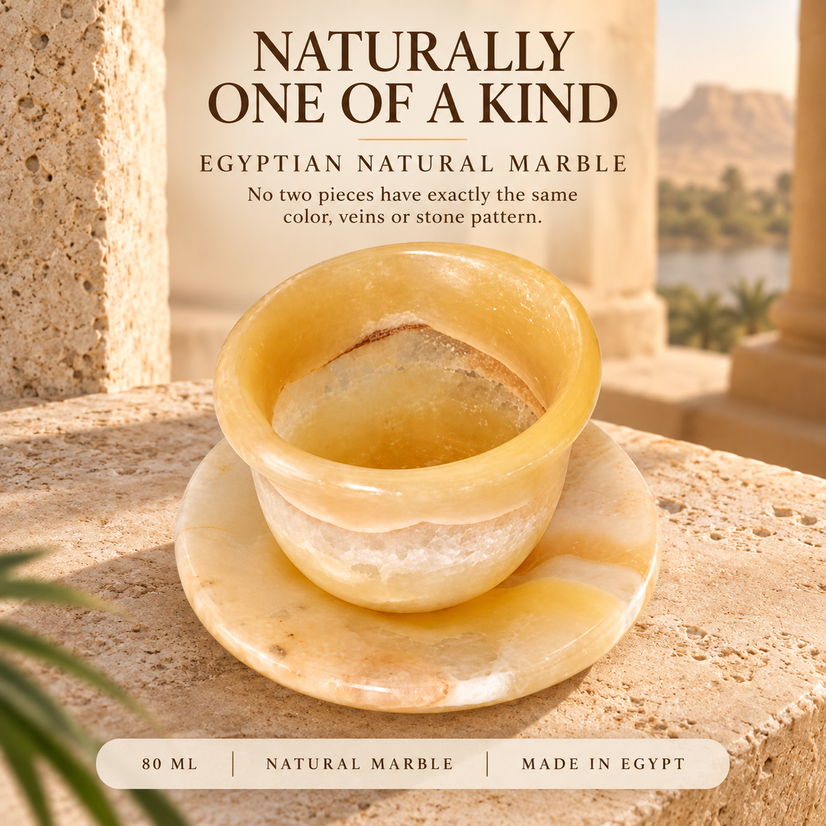 A small natural Egyptian marble cup with matching saucer, displayed on a stone surface with a blurred outdoor Egyptian landscape in the background. Text at the top reads 'NATURALLY ONE OF A KIND' and 'EGYPTIAN NATURAL MARBLE', with a bottom label reading '80 ML | NATURAL MARBLE | MADE IN EGYPT'.