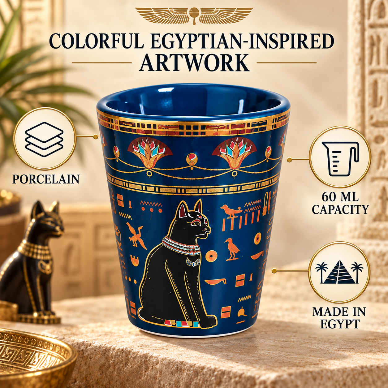 A blue and gold ceramic cup with an Egyptian cat illustration and hieroglyphic motifs, shown on a stone surface with decorative props. Text around the cup highlights porcelain, 60 ml capacity, and made in Egypt.