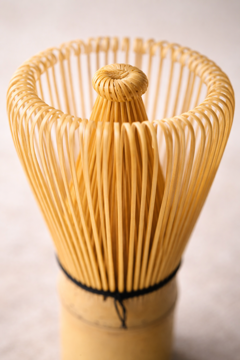 Wooden whisk used for making matcha tea on a light background
