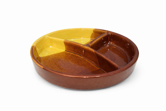 Ceramic dish with divided sections in brown and yellow on a white background