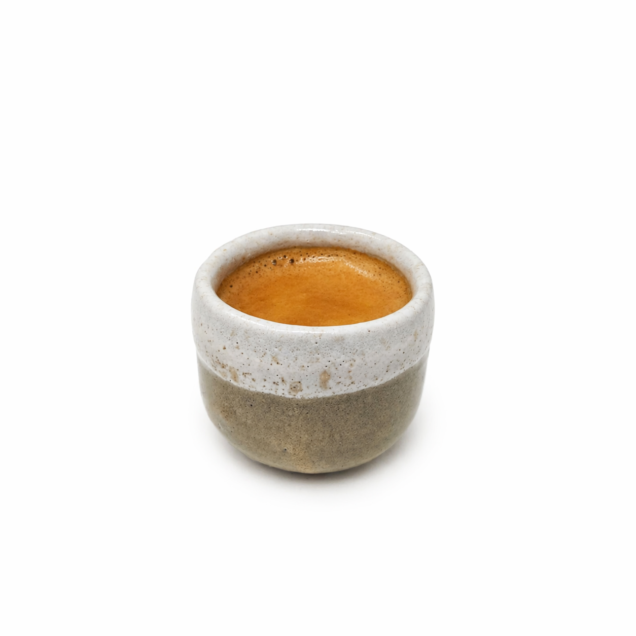 Ceramic espresso cup with a small amount of coffee on a white background