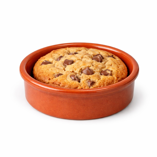 Cookie with chocolate chips in a terracotta dish on a white background