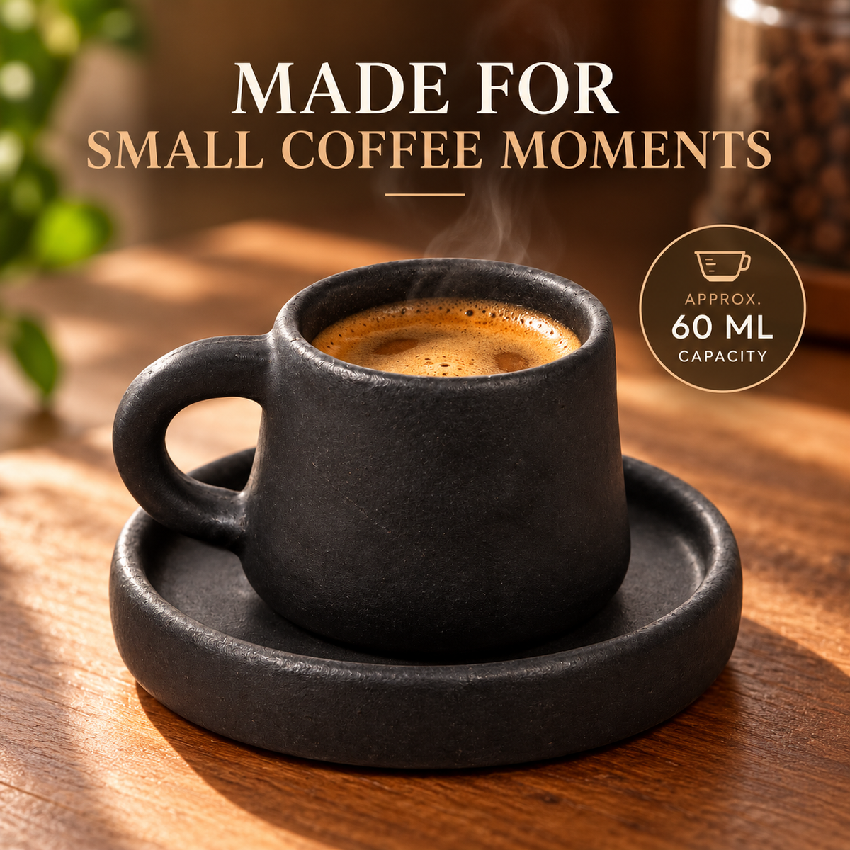 A matte black ceramic espresso cup with a matching saucer on a wooden table, filled with coffee and shown with text reading 'MADE FOR SMALL COFFEE MOMENTS' and a '60 ML CAPACITY' badge.