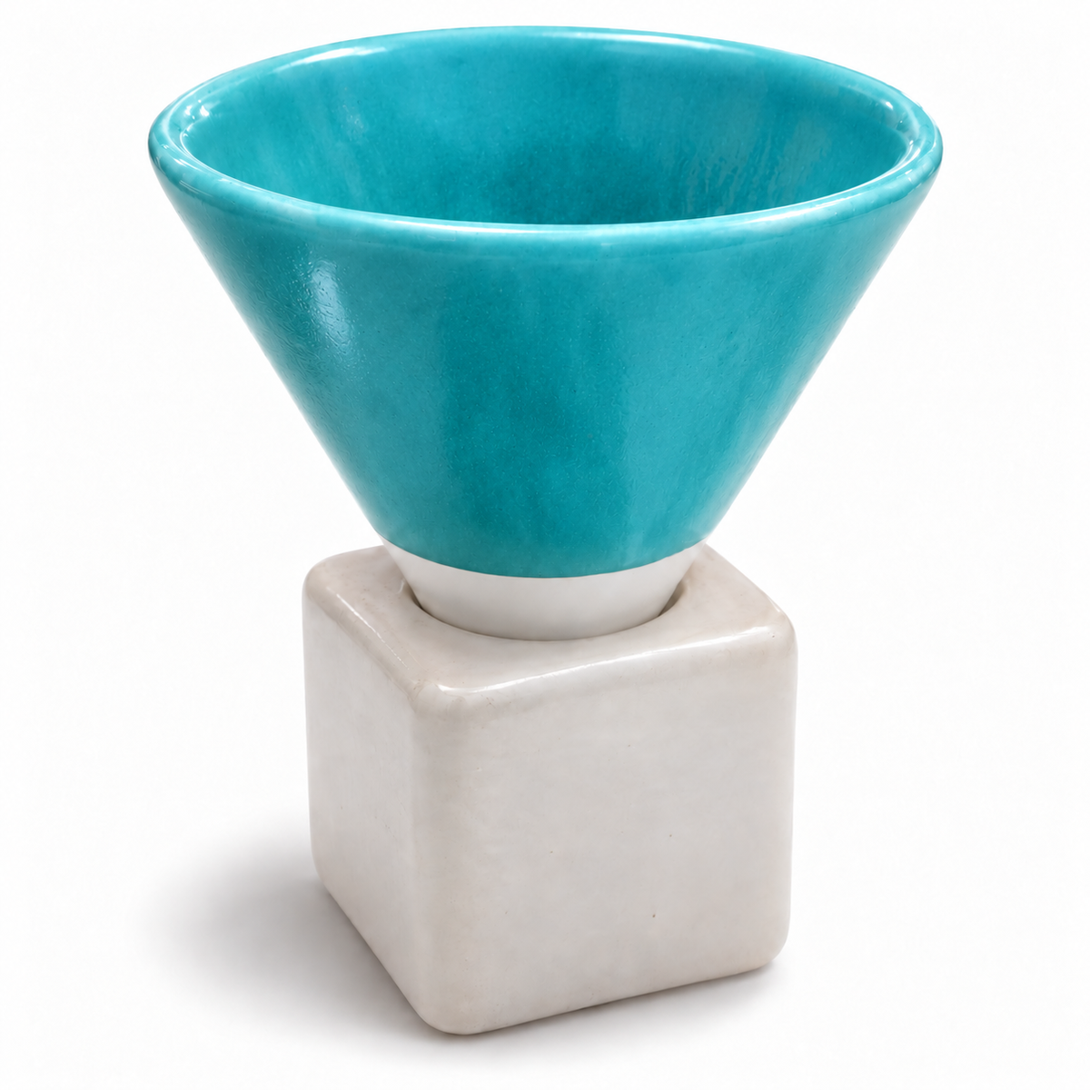 A ceramic cup with a glossy turquoise blue conical upper section and a matte off-white square base, shown on a clean white background.