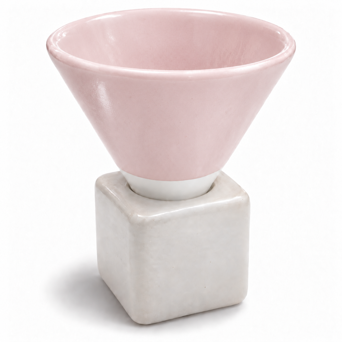 A ceramic cup with a light pink conical upper section and a matte off-white square base, shown on a clean white background.