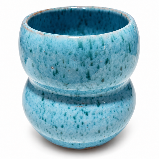 A small ceramic planter or vase with a two-tiered stacked design, featuring a glossy light blue glaze with dark teal speckles, set against a plain white background.