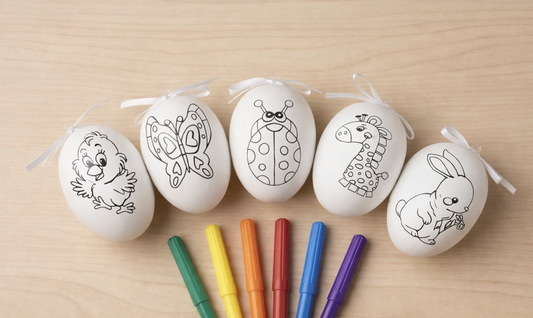 Coloring Easter eggs with black outlines of animals on a wooden surface with markers.