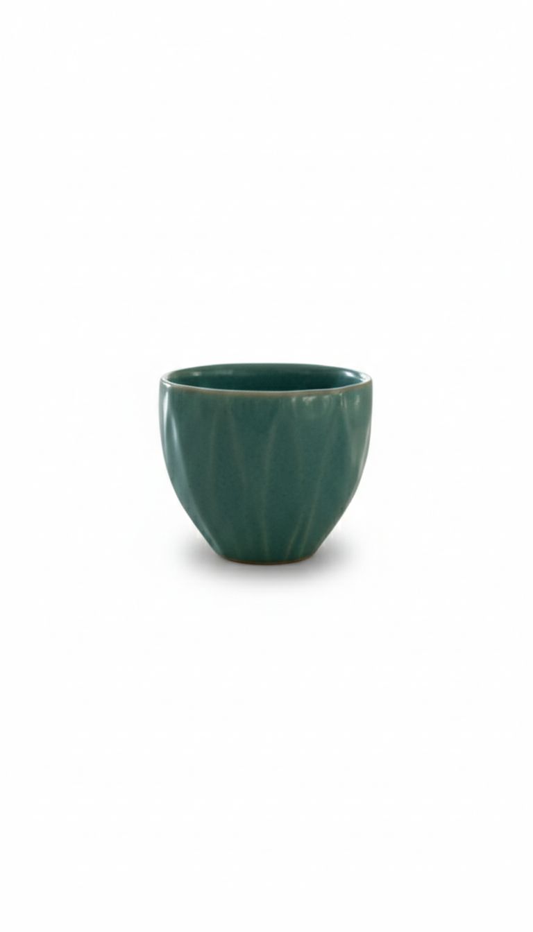 Green ceramic cup on a white background