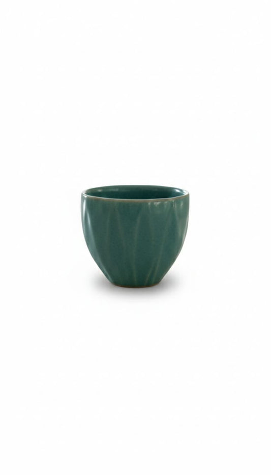 Green ceramic cup on a white background