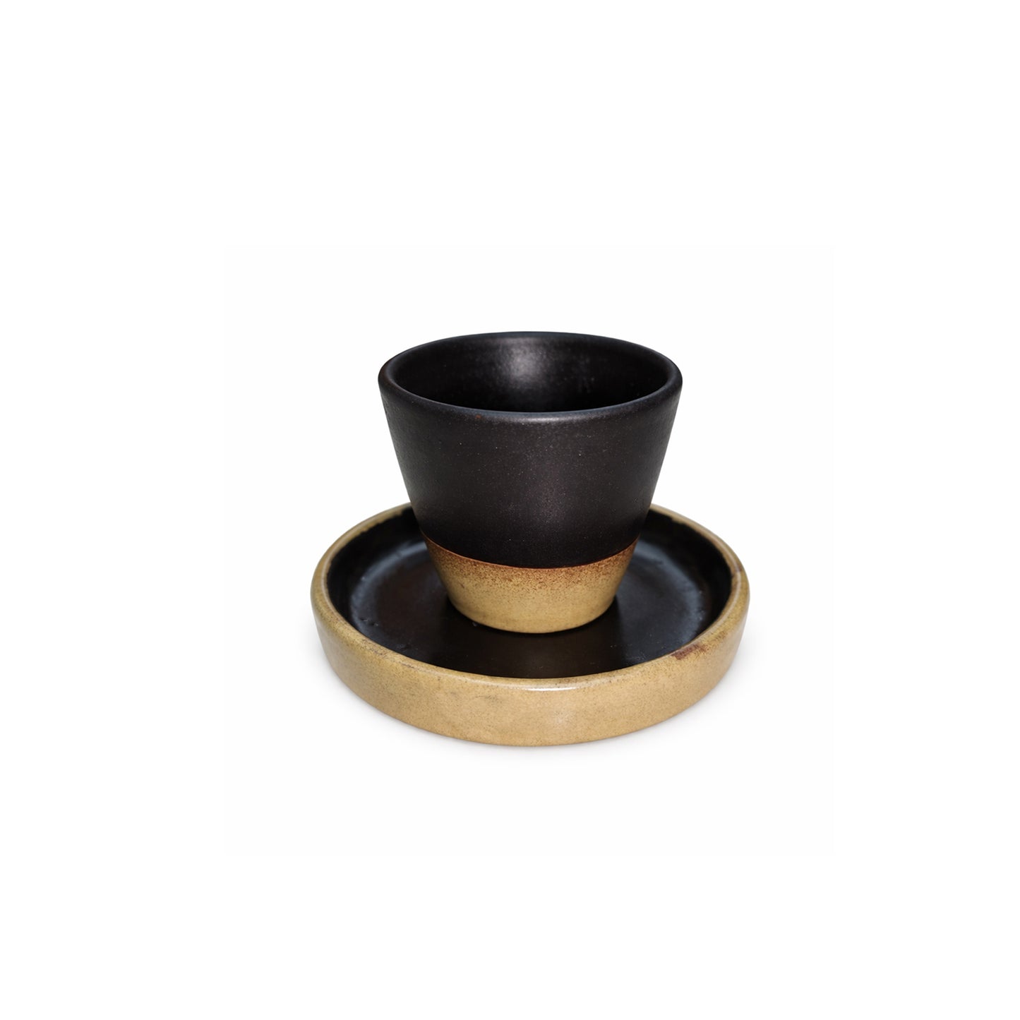 Black ceramic cup with beige base on a matching saucer against a white background