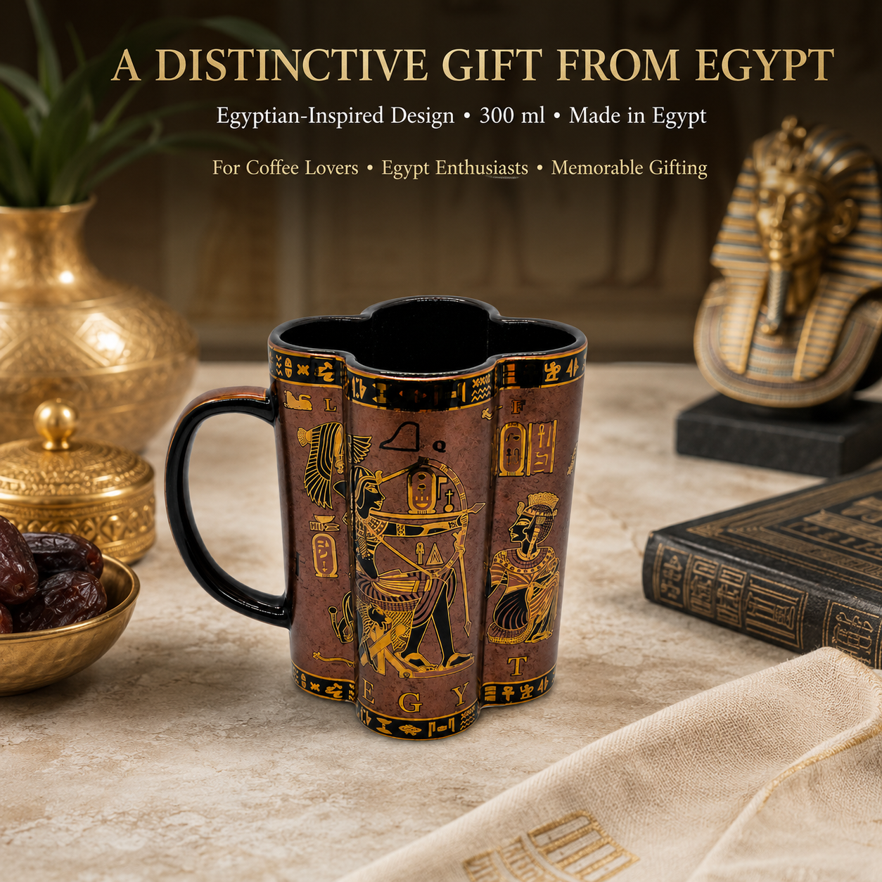 A 300 ml ceramic mug with an Egyptian-inspired design, featuring a dark brown and gold hieroglyphic pattern, displayed on a stone surface with Egyptian-themed props including a gold pharaoh statue, a black book, and a gold vase.