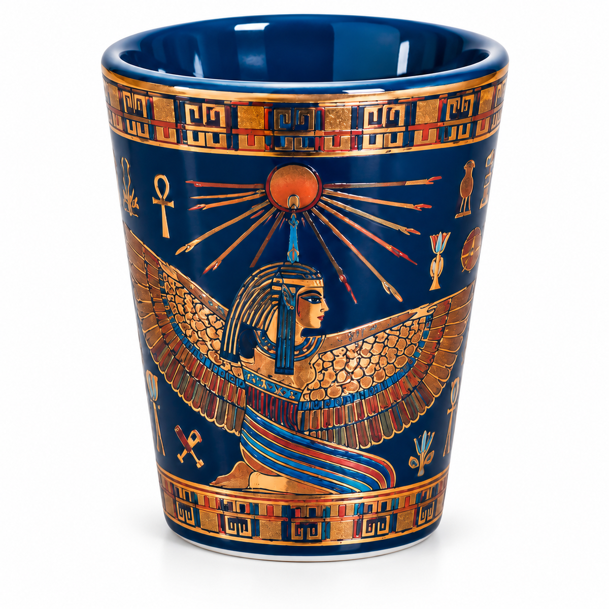 A ceramic cup featuring an Egyptian design with a blue background, gold borders, and a central figure of a winged pharaoh under a sun motif.
