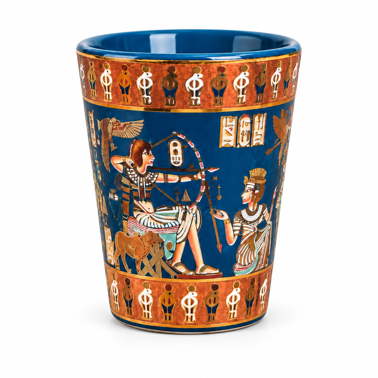 A ceramic Egyptian-themed cup featuring a deep blue body decorated with gold borders and ancient Egyptian figures and symbols, set against a plain white background.