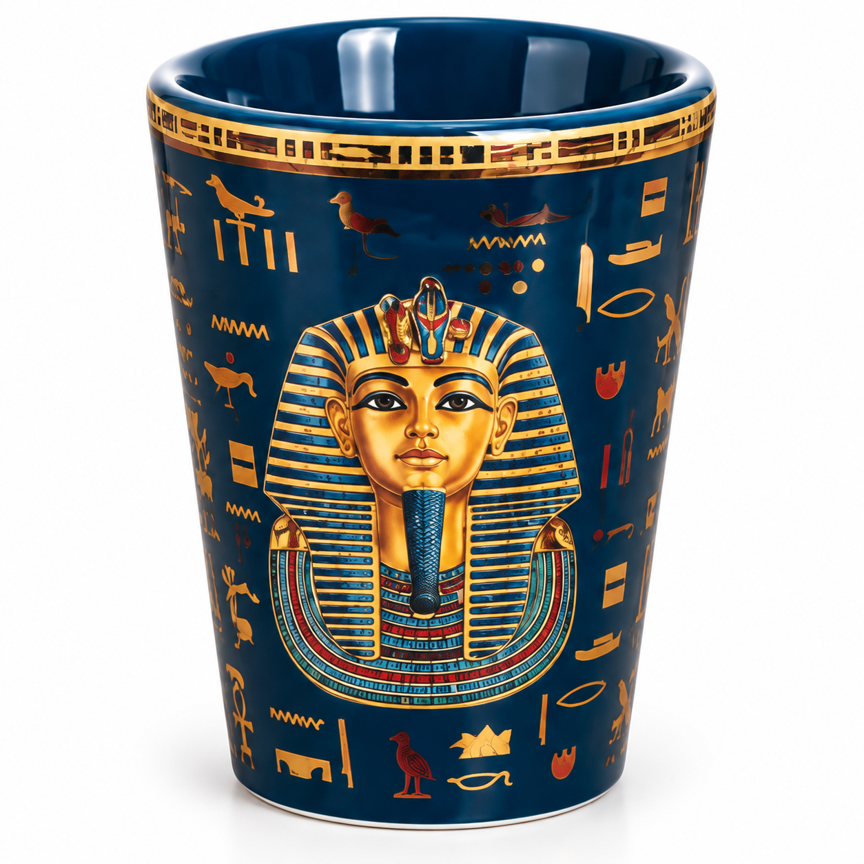A dark blue ceramic cup featuring a detailed illustration of Pharaoh Tutankhamun in gold and blue, surrounded by Egyptian hieroglyphs, on a clean white background.
