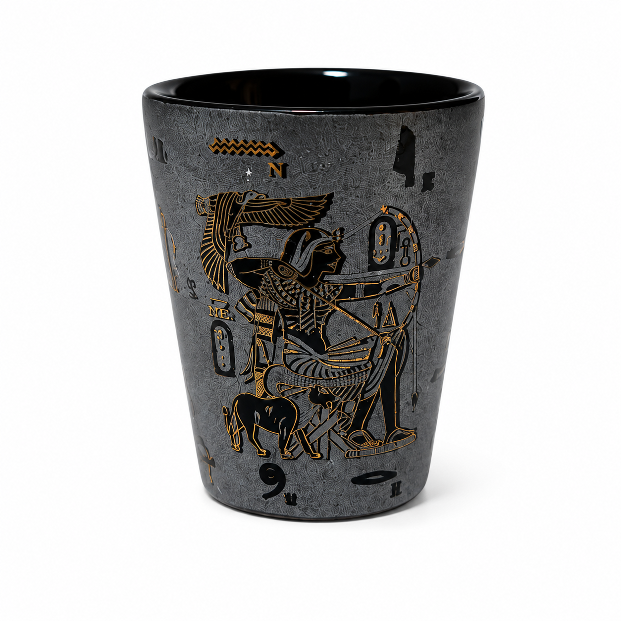 A dark gray ceramic shot glass featuring an ancient Egyptian illustration in gold and black, depicting a figure with a bow and arrow and a dog, set against a plain white background.