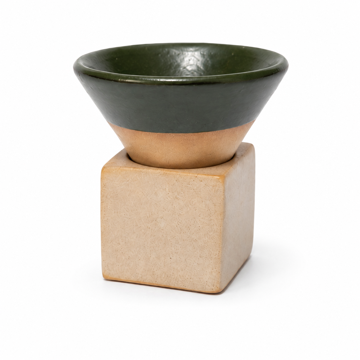 A ceramic coffee cup with a glossy dark green top and a natural beige clay base, resting on a matching square beige ceramic stand against a white background.