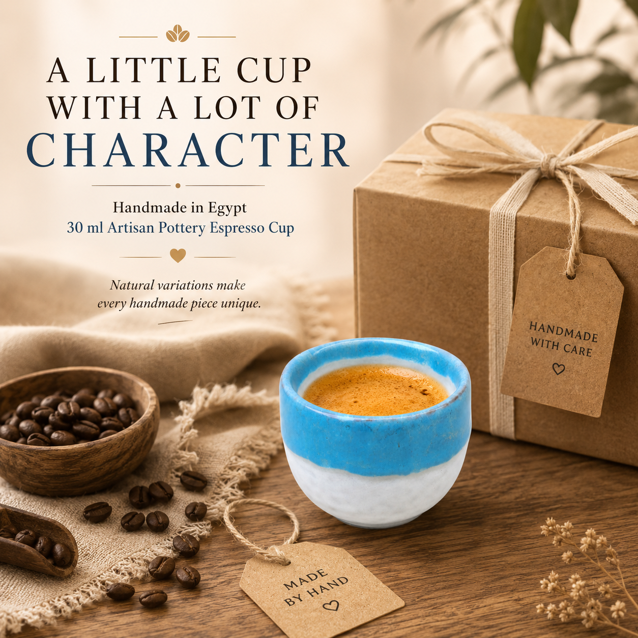 A handmade ceramic espresso cup with a blue and white glazed finish, filled with espresso, displayed on a wooden table alongside coffee beans, a kraft gift box tied with twine, and text reading 'A LITTLE CUP WITH A LOT OF CHARACTER'.