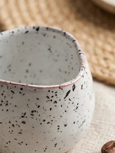 Speckled ceramic mug on a textured surface
